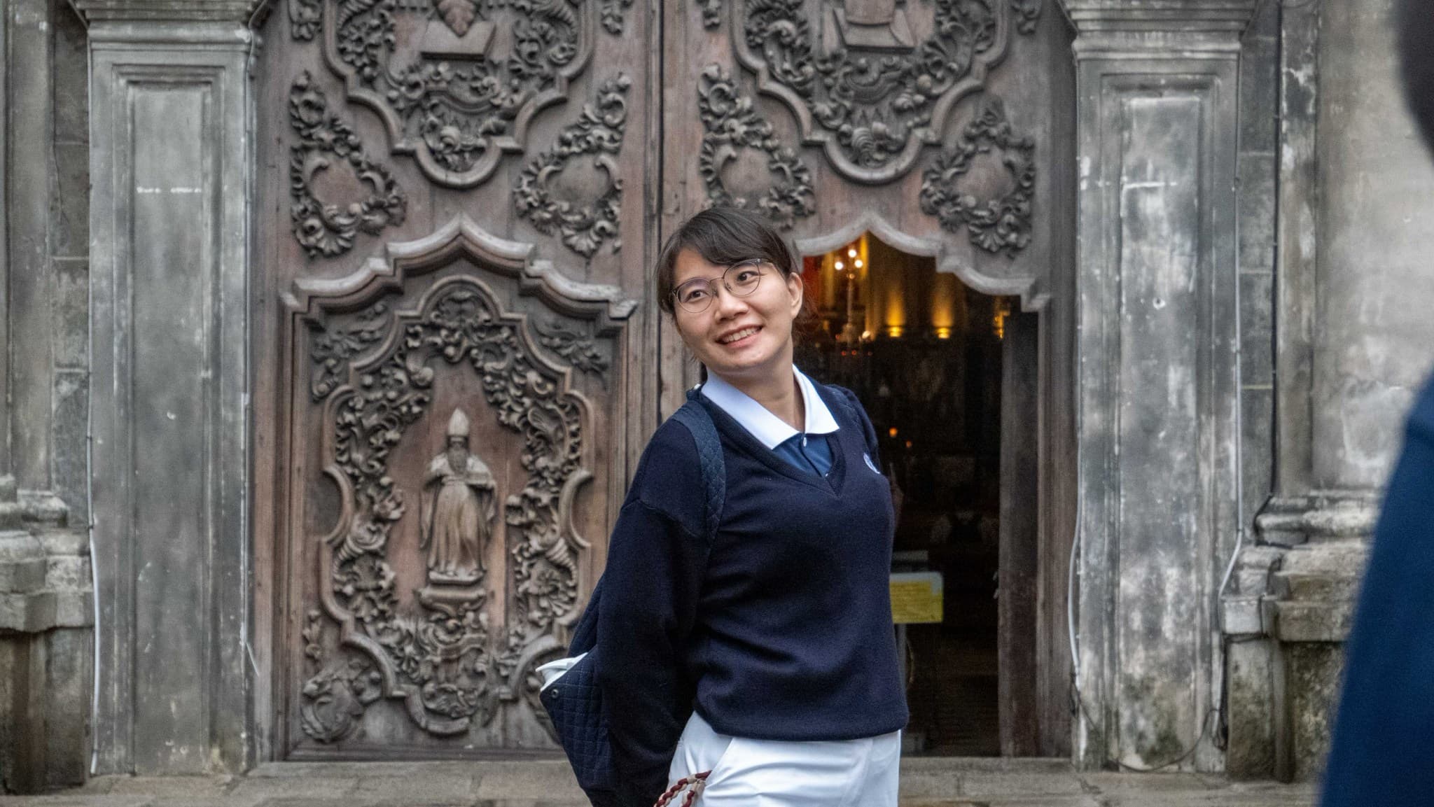 When at the San Agustin Church, have a picture taken by the main entrance, whose molave door features intricate carvings of floral patterns and religious references.