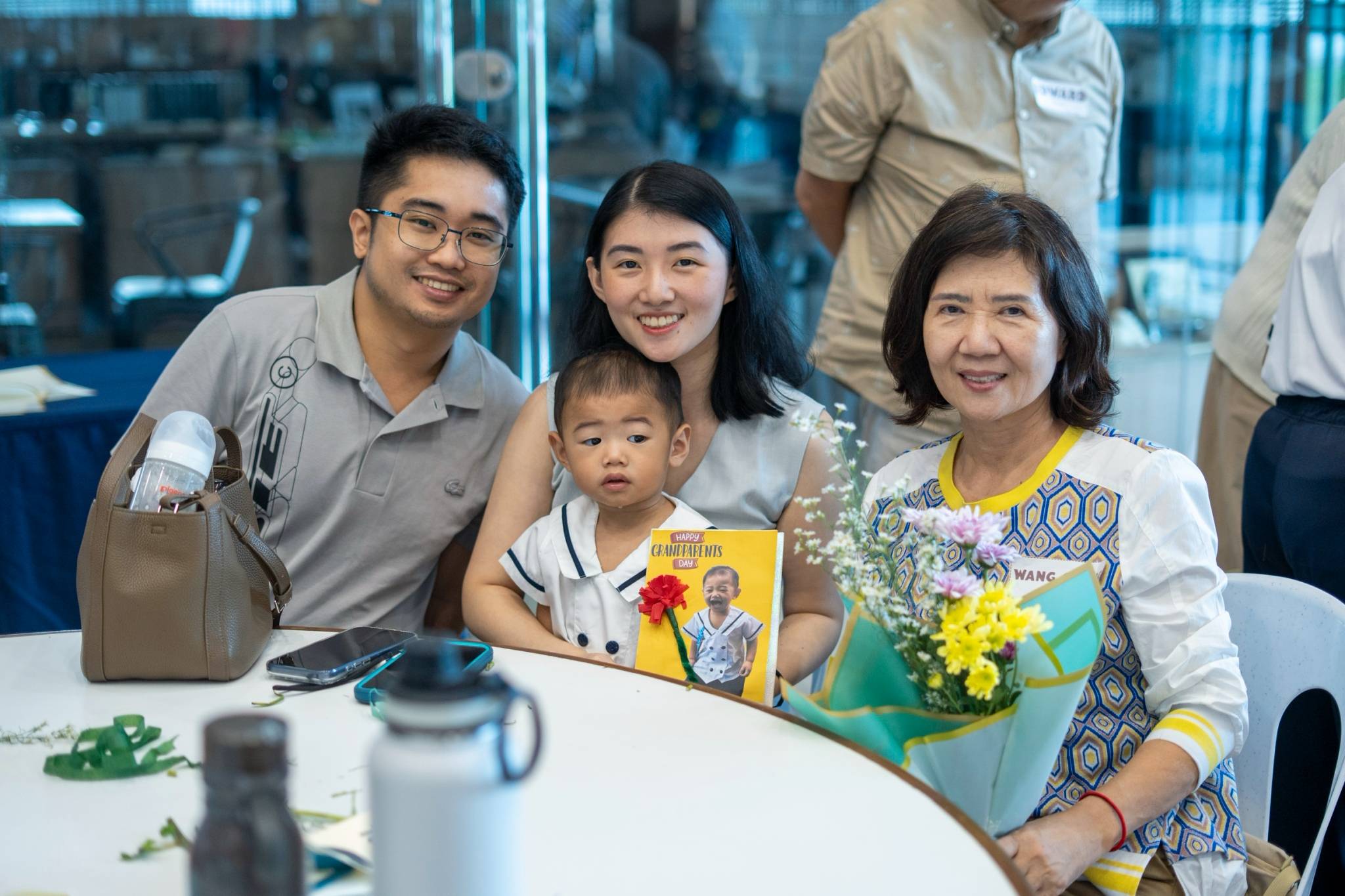 In a picture of pure love, families share warm smiles and display their special cards.