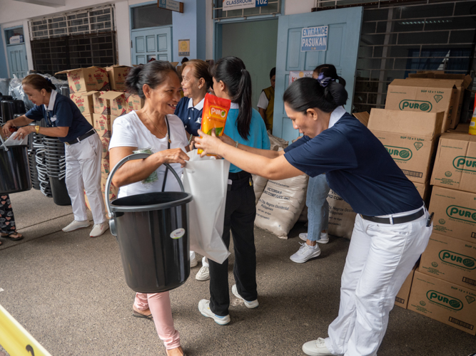 Engresia Dagaas (left) happily receives cooking essentials from a Tzu Chi volunteer.