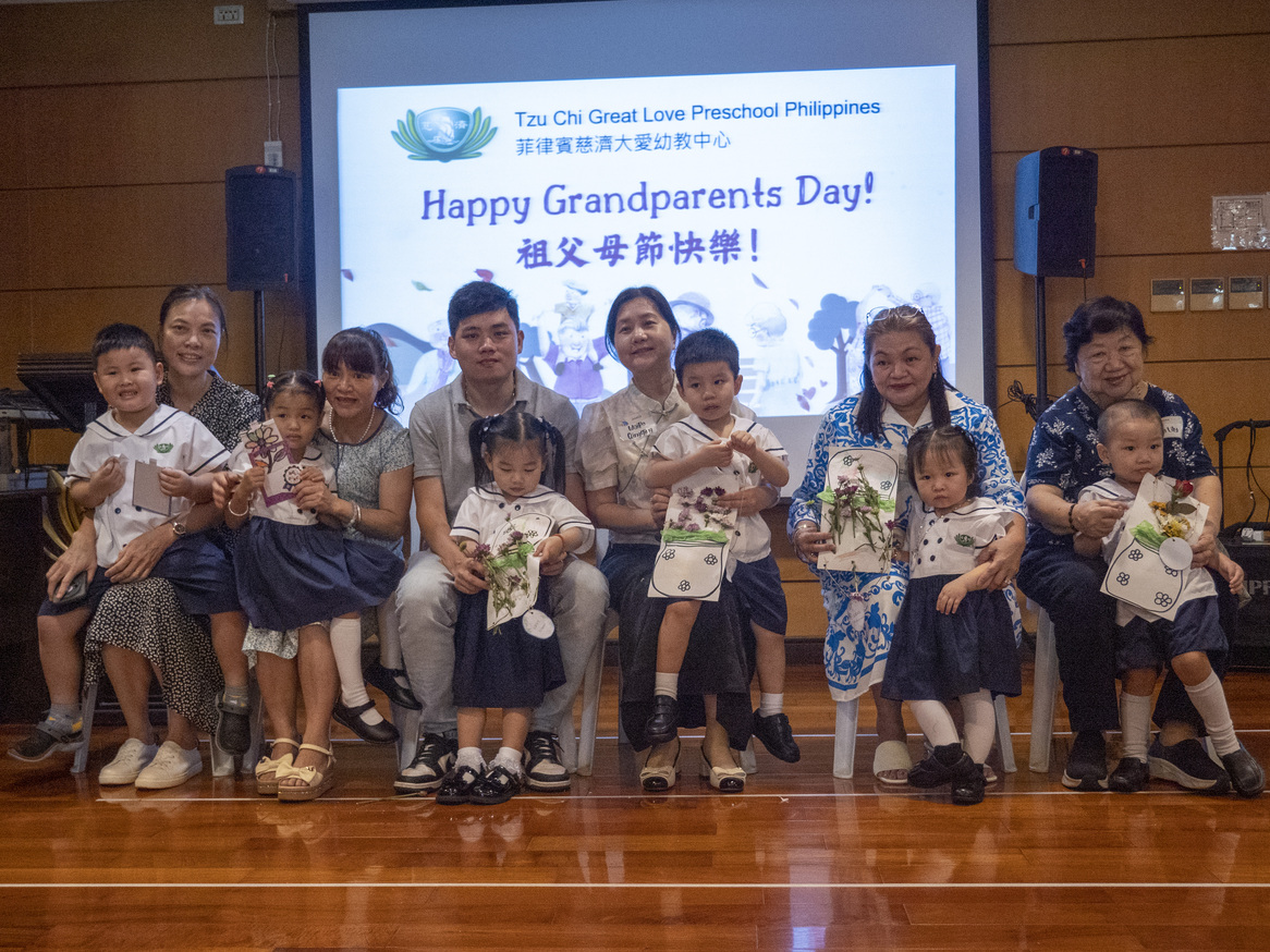 Grandparents happily take a photo together after receiving handmade gifts.