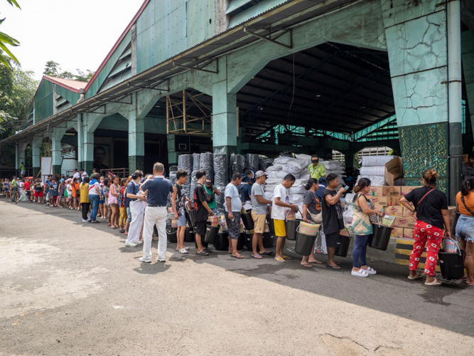 Beneficiaries line up as they receive their relief goods.