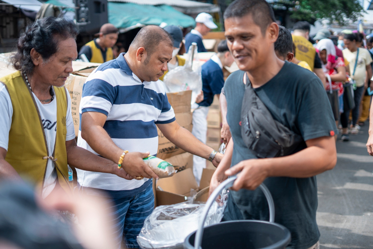 Barangay 20 Chairman Anthony Igus joins Tzu Chi volunteers in distributing relief items to the affected residents. 