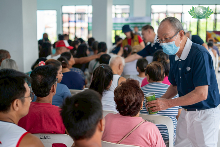 A Tzu Chi volunteer accepts donations from Hagonoy beneficiaries affected by flooding.