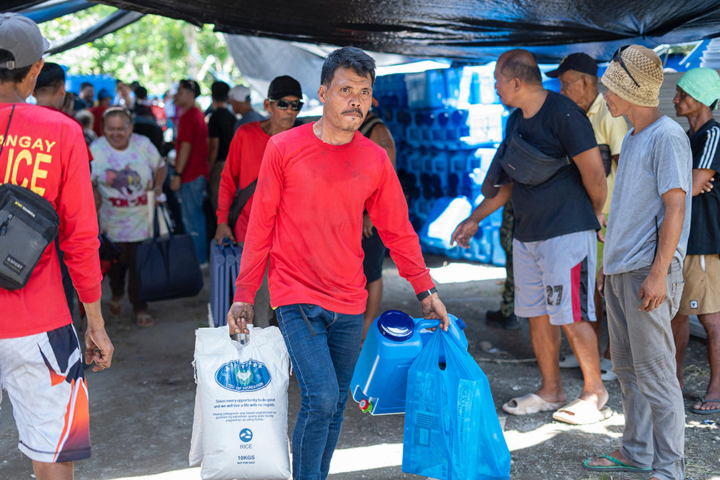 Representatives from different households leave Tzu Chi’s distribution area with their relief items.