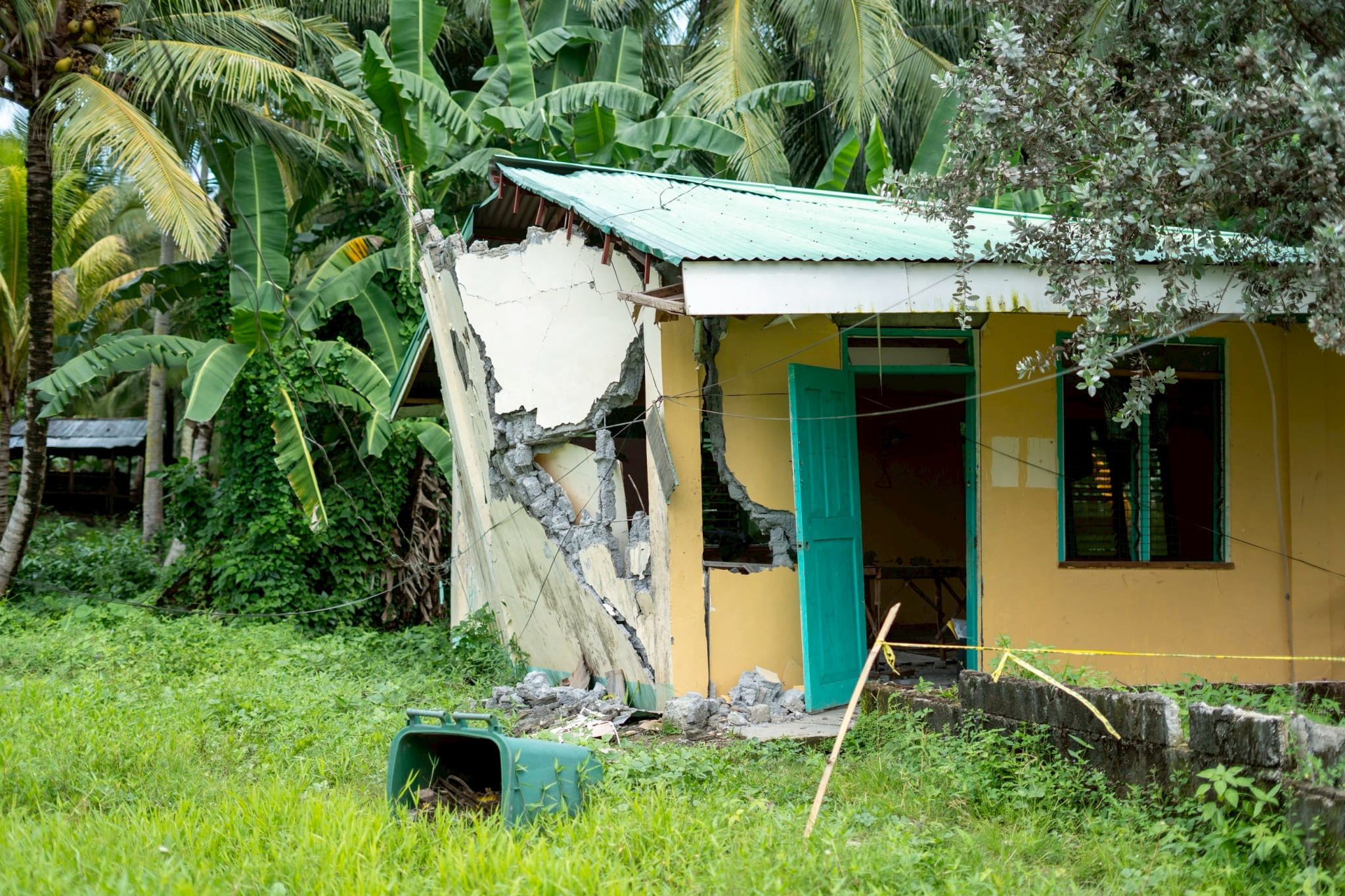 The earthquake caused the heavy concrete walls to crack and collapse, leaving the structure in ruins.