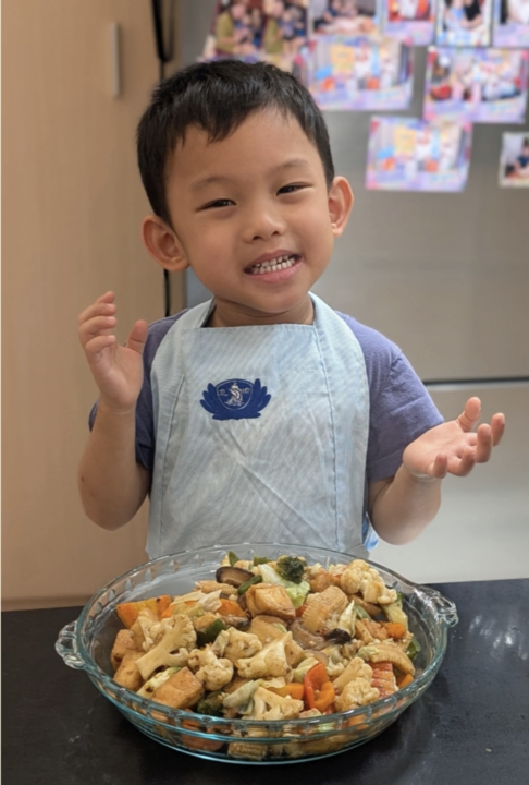 A pre-kindergarten student shows off the stir-fried dish he prepared.