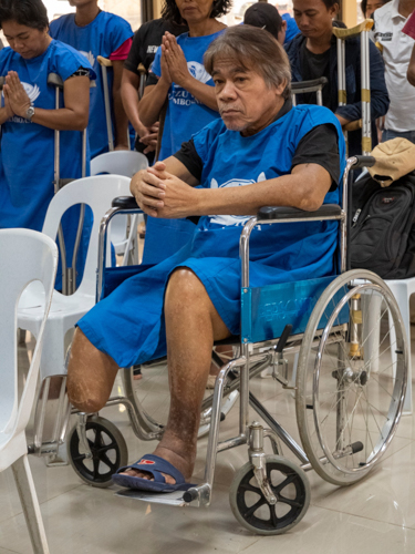 A prosthesis beneficiary prays before receiving his prosthesis and learning to walk once more.