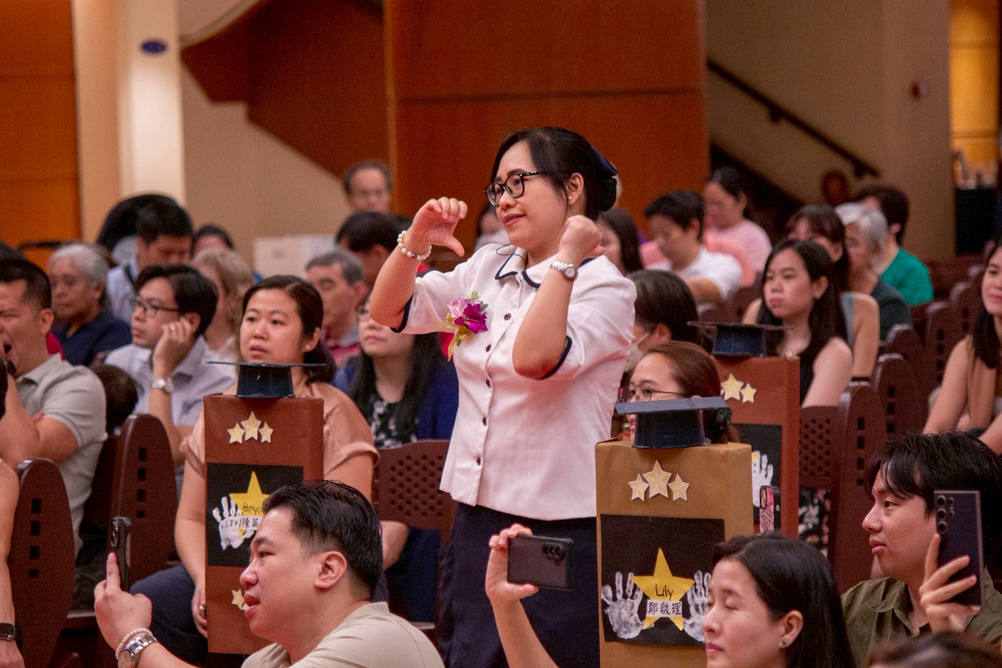 Teacher Beni Polican coaches the students’ dance from the audience.