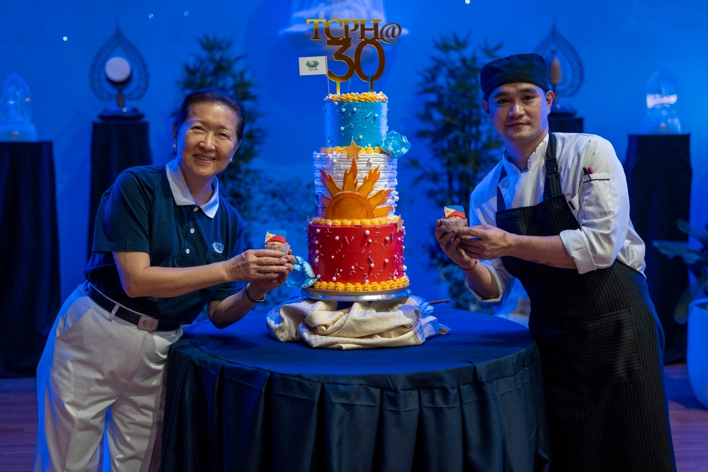 Tzu Chi volunteer Sally Yuñez (left) poses for a photo with Adrian Neil Ang (right) after successfully presenting the cake at the 30th Anniversary of Tzu Chi Philippines.