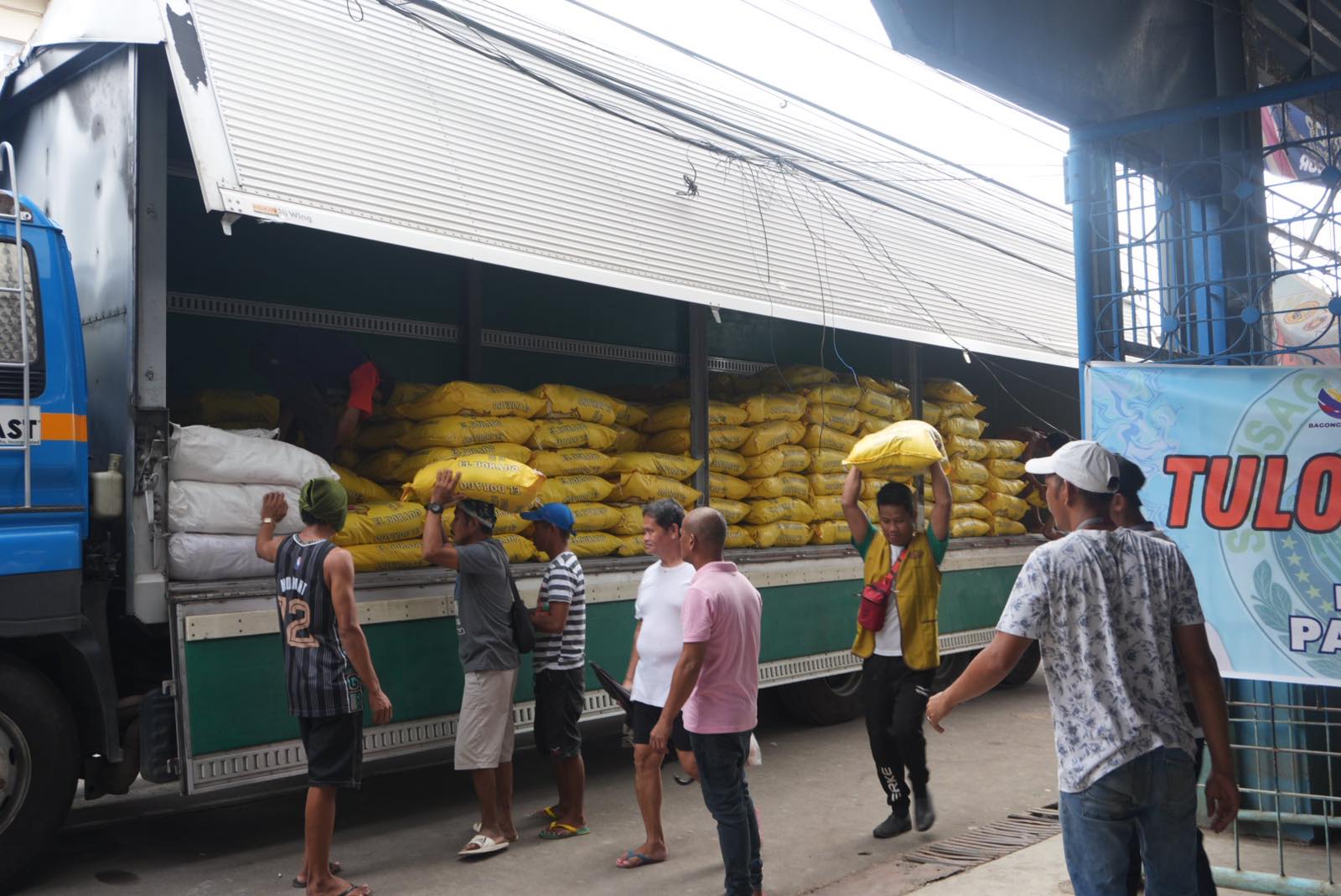 Volunteers unload the sacks of rice for distribution.