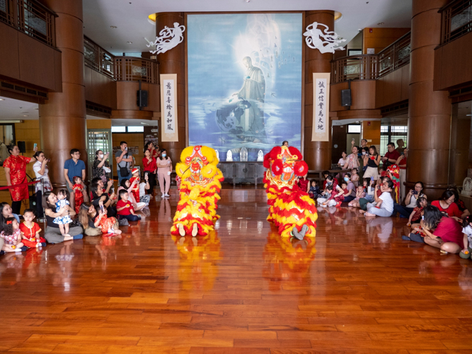 Families whip out their cell phones to take a picture of lion dancers paying their respects to Buddha. 