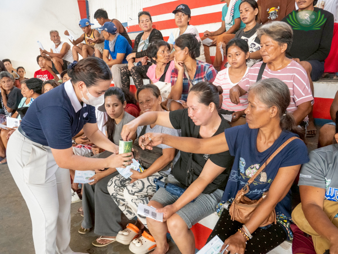 Despite losing her home and personal belongings to the flood, Crechell Campilan (in black) didn’t hesitate to donate when volunteers passed around coin cans. 