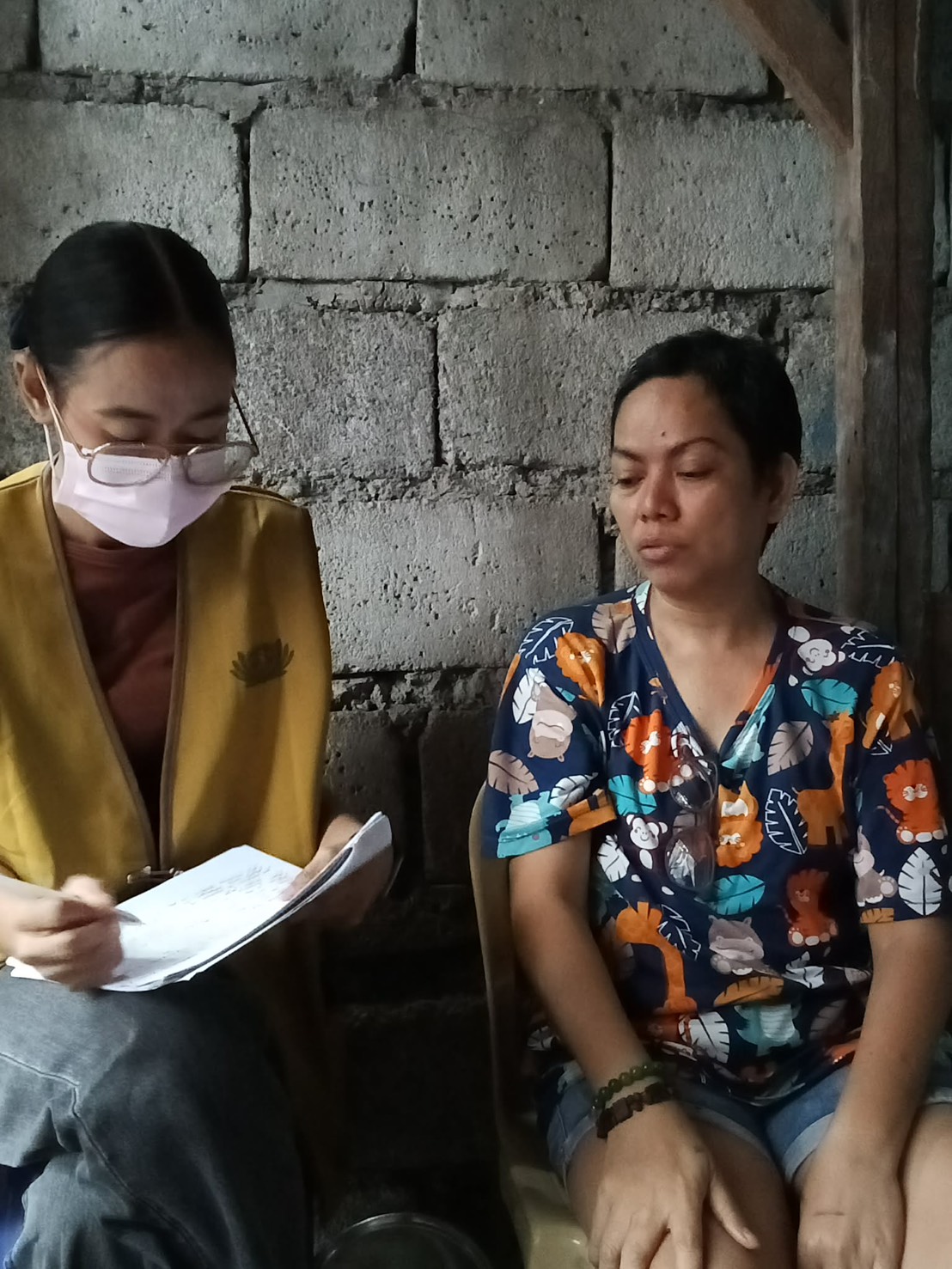 Charity Department Social Welfare Officer Liane Margallo (left) interviews Roselyn Rodriguez during a home visit. 