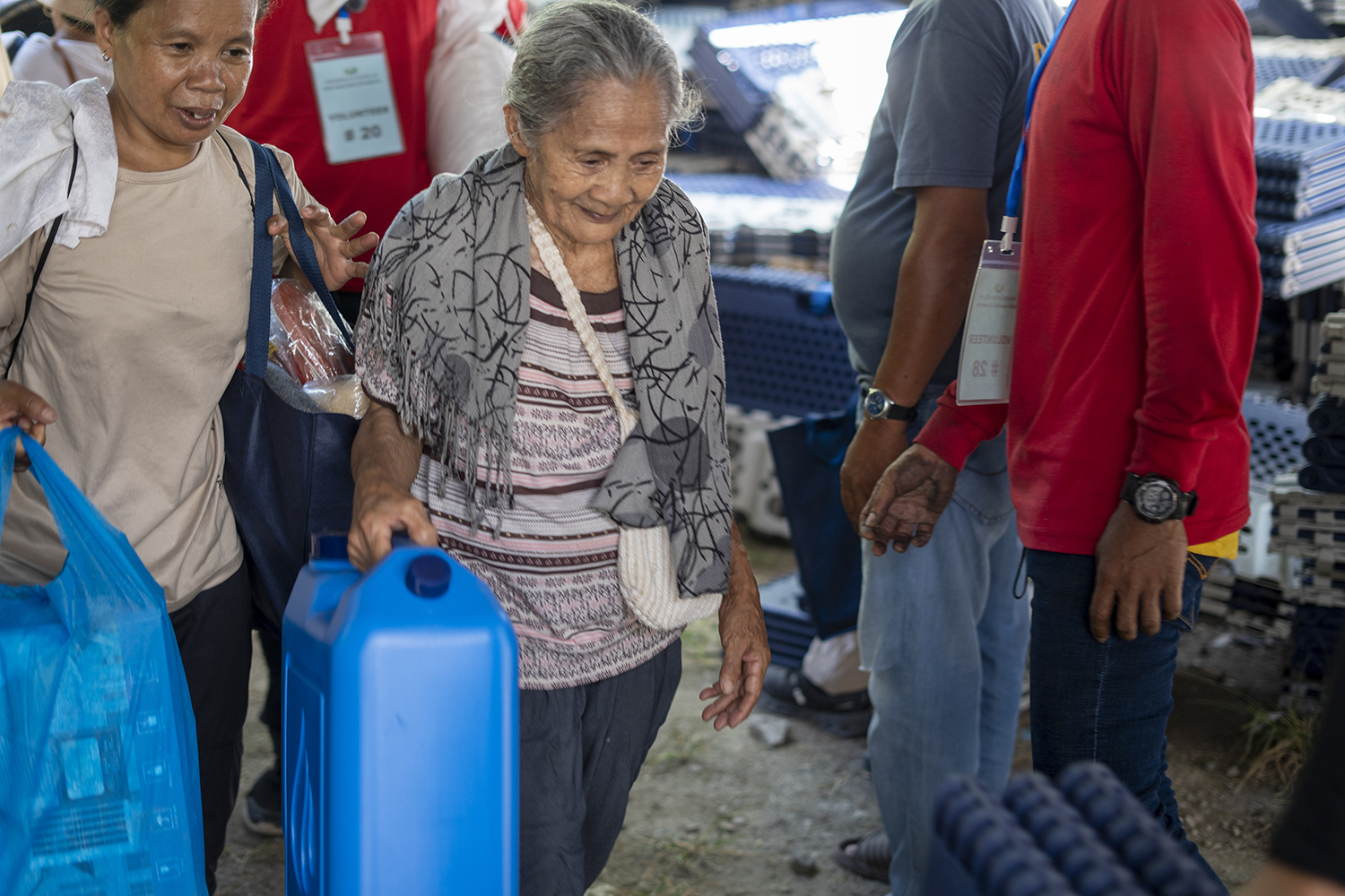 Representatives from different households leave Tzu Chi’s distribution area with their relief items. 