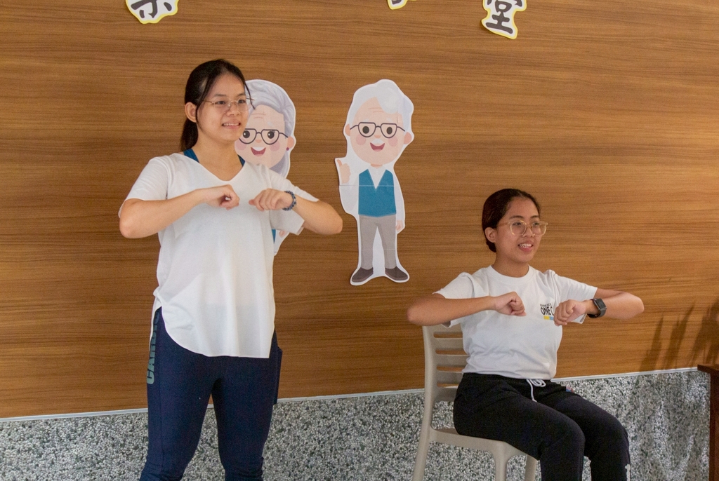 Professional physical therapists Annie Dixie Lim (left) and Ashley Pado lead seniors in a full-body workout of standing and seated aerobics.