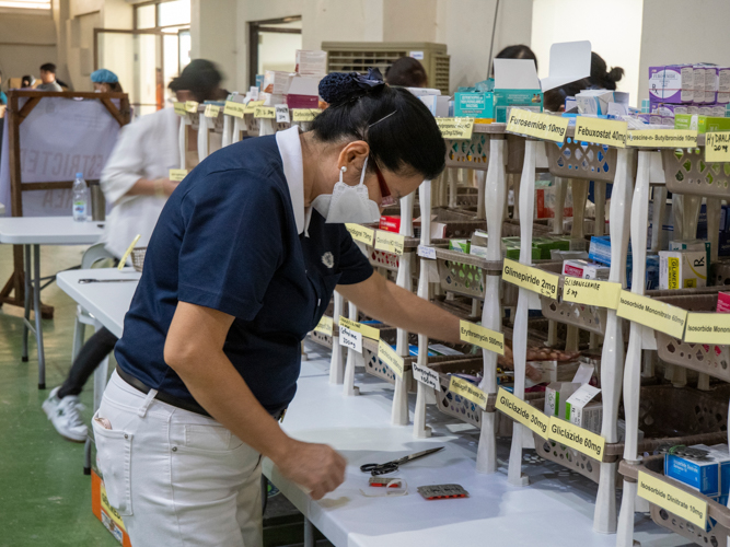 Tzu Chi volunteer Rosa So arranges the medicine in the pharmacy area.