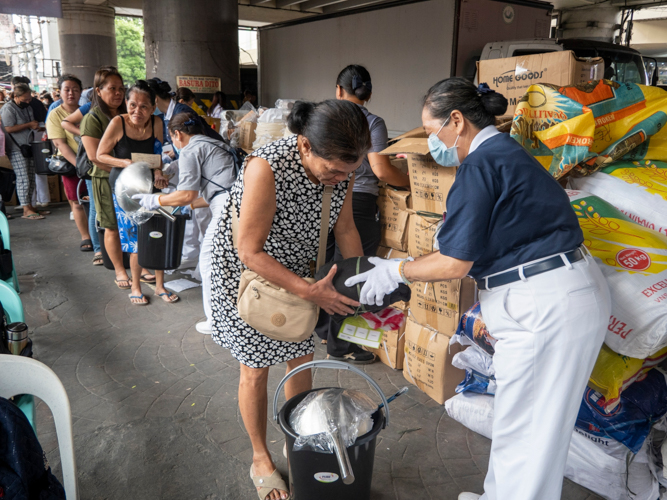 A Tzu Chi volunteer helps distribute relief goods.