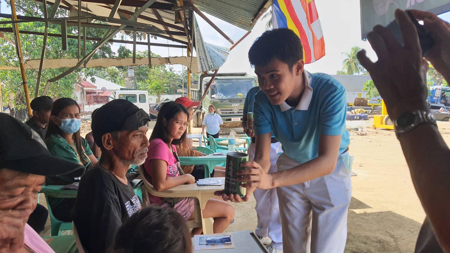 A Tzu Chi scholar invites beneficiaries to contribute what they can in a relief distribution in Cotcot, Liloan.
