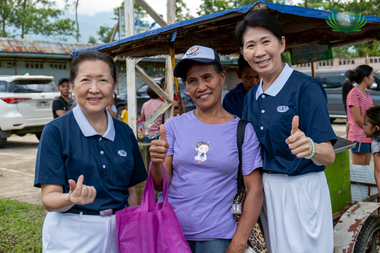 Flanked by Tzu Chi volunteers Sally Yuñez (left) and Woon Ng (right), Inocencia Gelaver says “thank you” with a thumbs-up sign.
