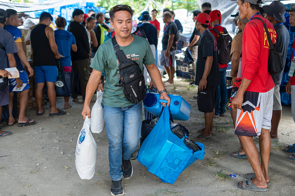 Representatives from different households leave Tzu Chi’s distribution area with their relief items.