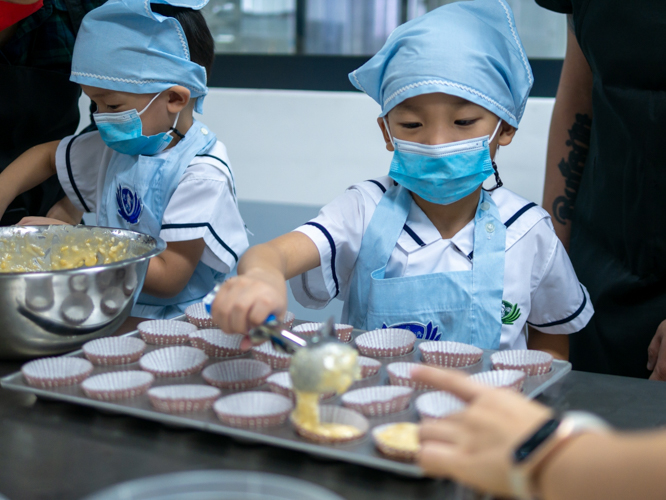 Brothers Ethan and Dylan Ngo help prepare banana streusel cupcakes. 【Photo by Daniel Lazar】