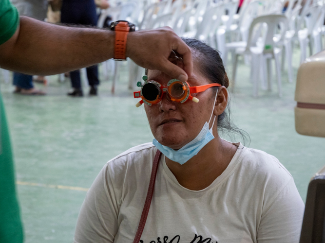 A beneficiary’s visual acuity is checked in the ophthalmology section. 1,111 patients went home with free eyeglasses.