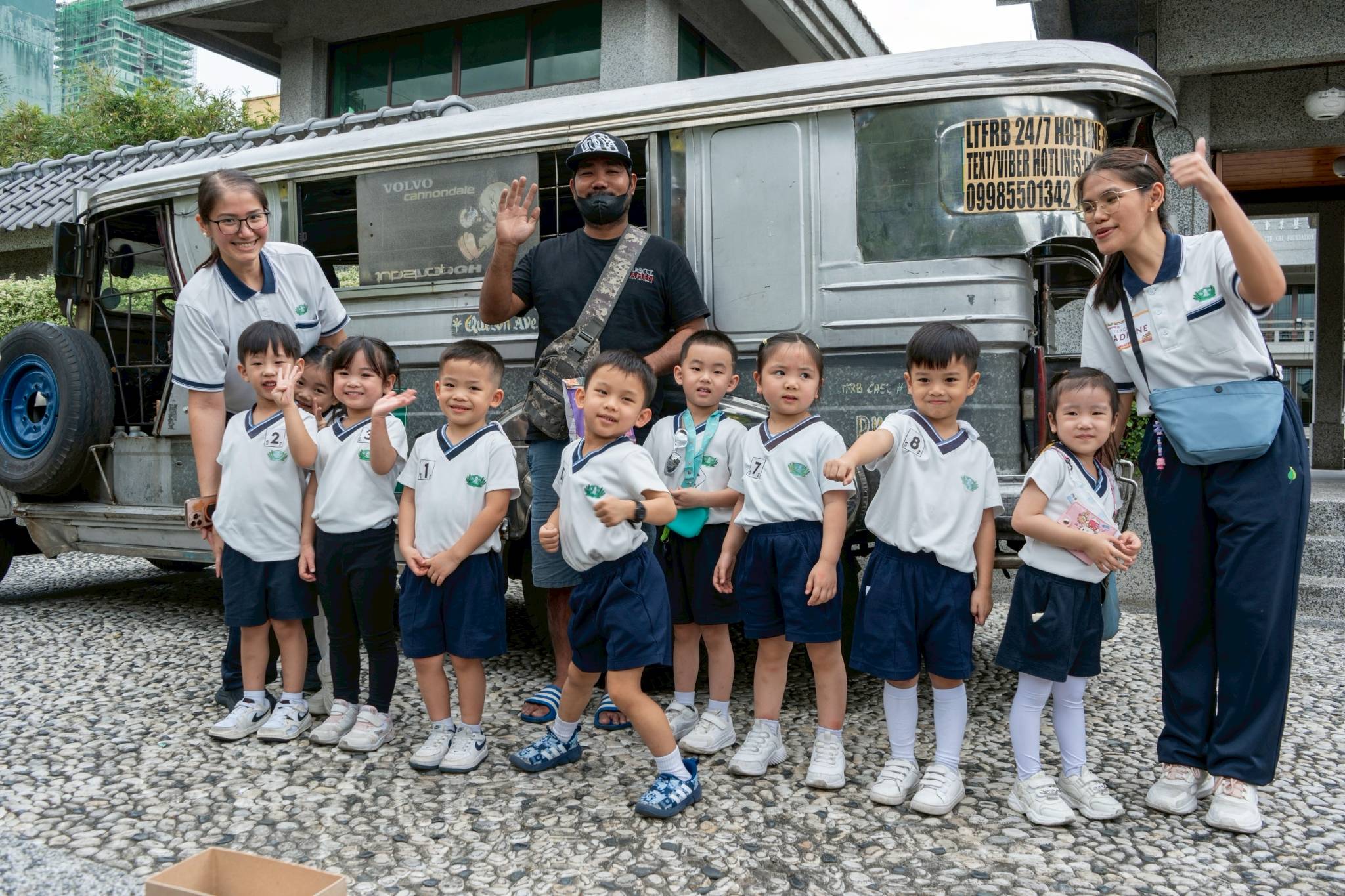 Kuya Ronald, the driver, poses with the students after a fun and safe ride.