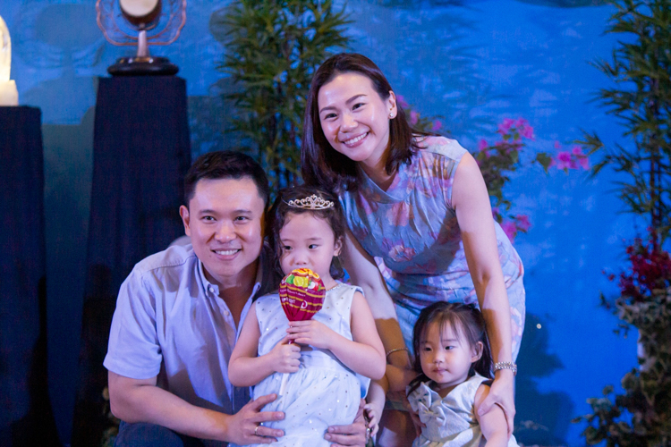 Sheena Tan (third from left), mother to student Harper Tan, takes a family photo after winning the newspaper dance game.