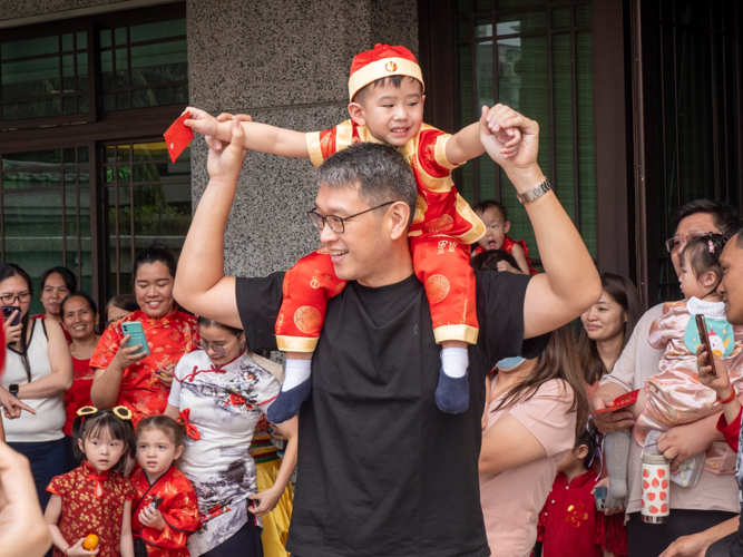 Father and son enjoy the colorful lion dance performance. 