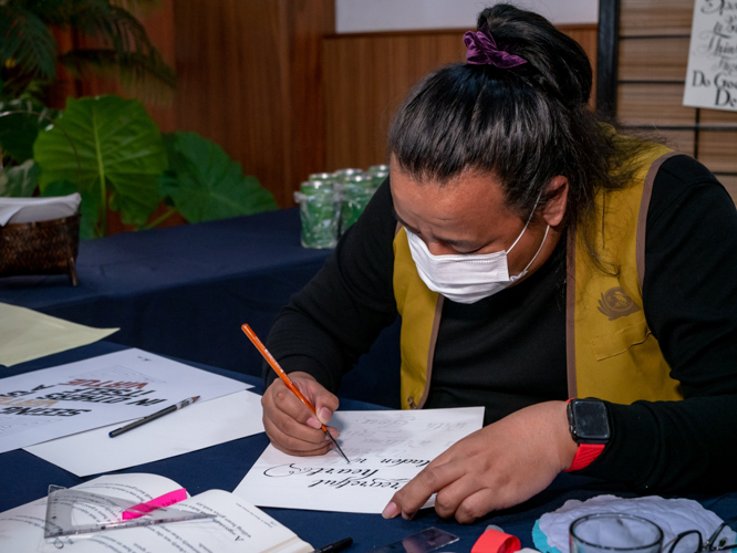 The lone artist of calligraphy in English at Tzu Chi’s New Year Blessing on February 5 impressed guests with his painstaking brush strokes and beautiful creations.  【Photo by Daniel Lazar】