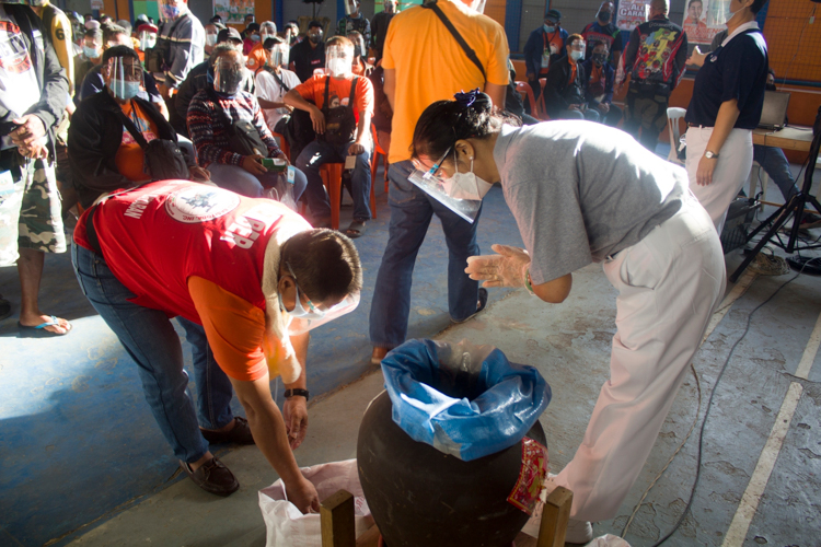 A tricycle driver places his pledge in a collection that will help Tzu Chi beneficiaries like him. 【Photo by Matt Serrano】