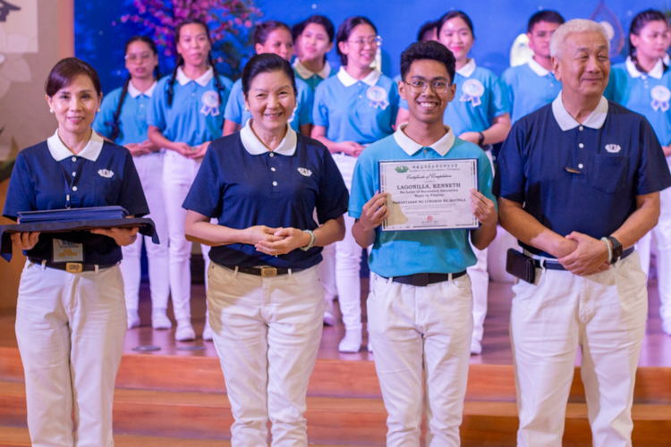 Kenneth Lagonilla (second from right), who graduates summa cum laude from his Bachelor of Secondary Education (Major in Filipino) from Pamantasan ng Lungsod ng Maynila, receives a symbolic Certificate of Completion from Tzu Chi Davao Deputy OIC  Ang Mei Yuan (first from left), Tzu Chi Education Committee Head Rosa So (second from left), and Tzu Chi Philippines CEO Henry Yuñez (first from right). 