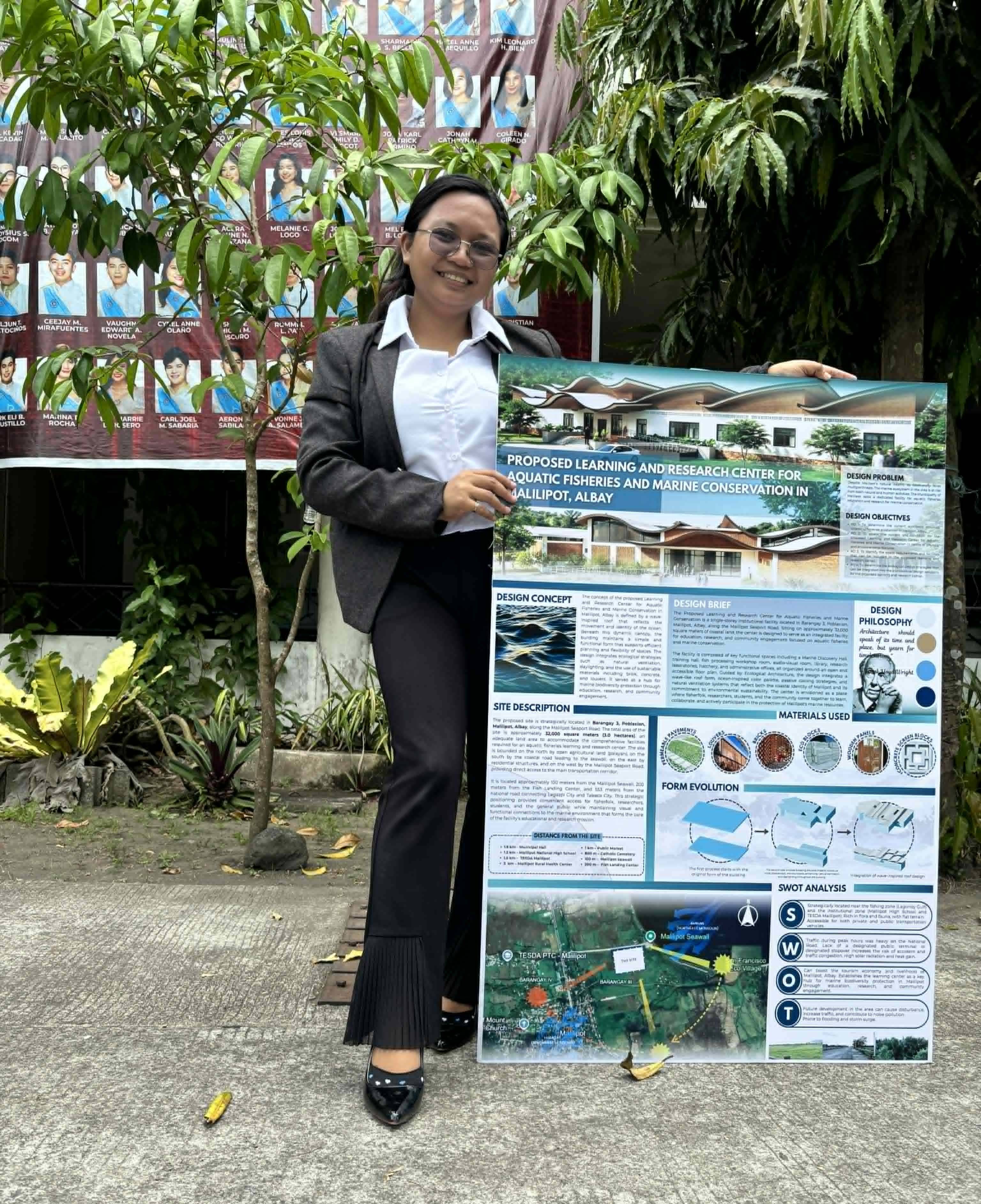 Patricia Paula Briz proudly showcases her presentation board after successfully passing her final thesis defense. 