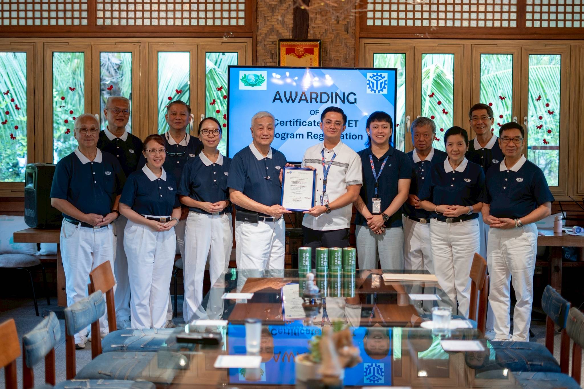 Representatives from Tzu Chi and TESDA pose for a photo with the Certificate of TVET Program Registration.
