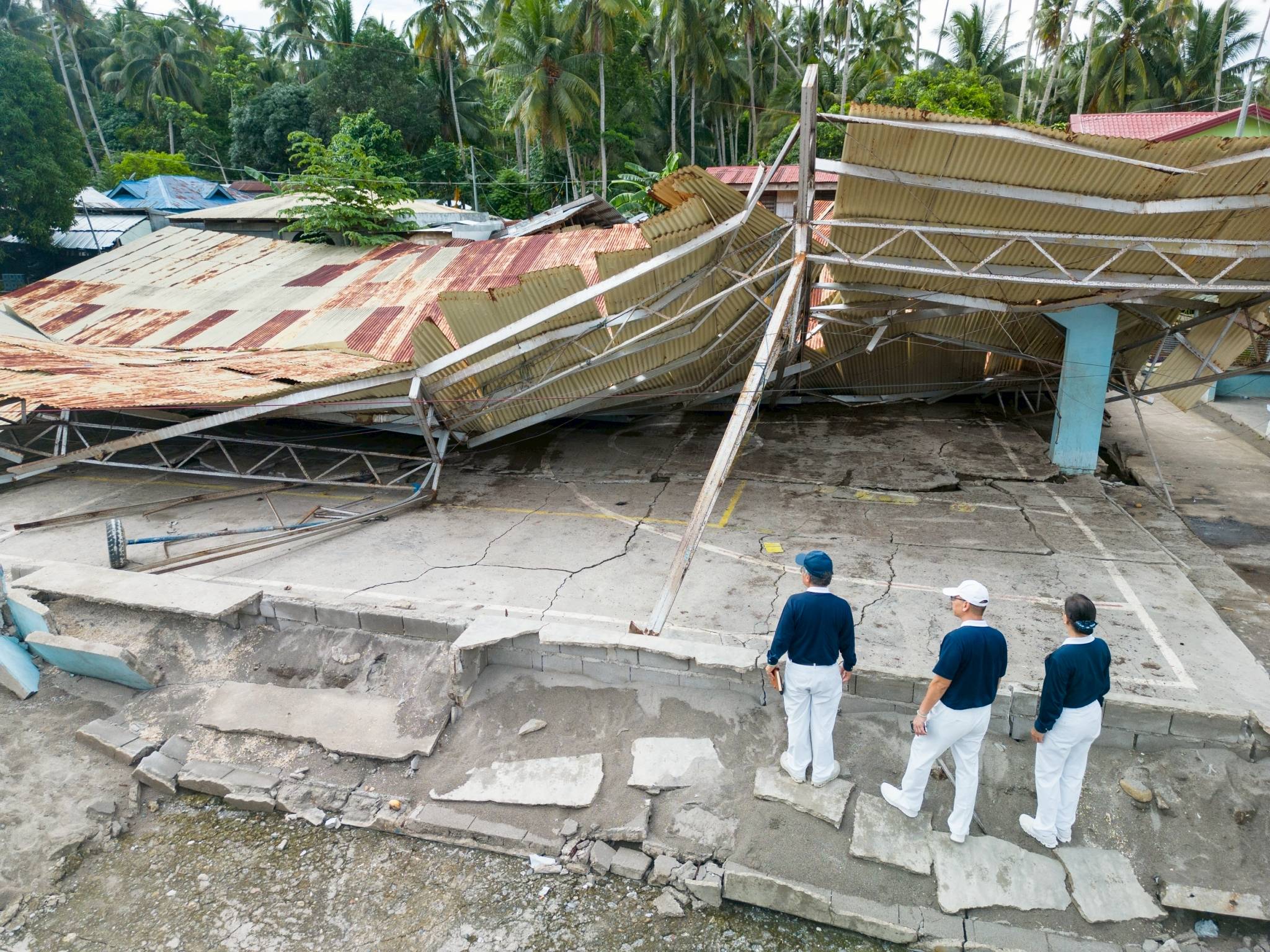 Tzu Chi volunteers can only stare at a covered court whose roof caved in from the powerful earthquake. 