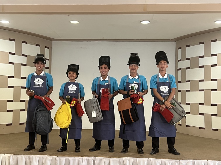 Five second year college scholars taking up shielded metal arc welding were each given a school bag, Tzu Chi coin bank, welding face shield and rod, heavy duty apron and gloves, and a Tzu Chi coin can. 