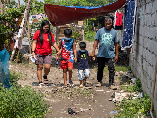 The Telecio family walk to their new humble  home beside the housing estate at Panghulo, Malabon.