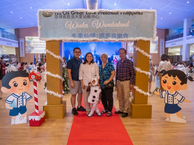 Families enjoy taking photos at the “Winter Wonderland: A Gratitude Concert” welcome arch.