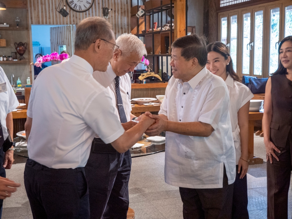 Angelo King Foundation, Inc. President Teddy Kingsu (third from right) shakes hands with Tzu Chi Taiwan CEO Po-wen Yen at a lunch held at the Tzu Chi café. 