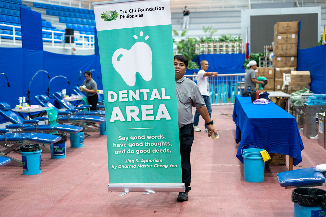 Tzu Chi staffer Wilfredo Ortiz Jr. prepares the dental area sign to guide patients. 