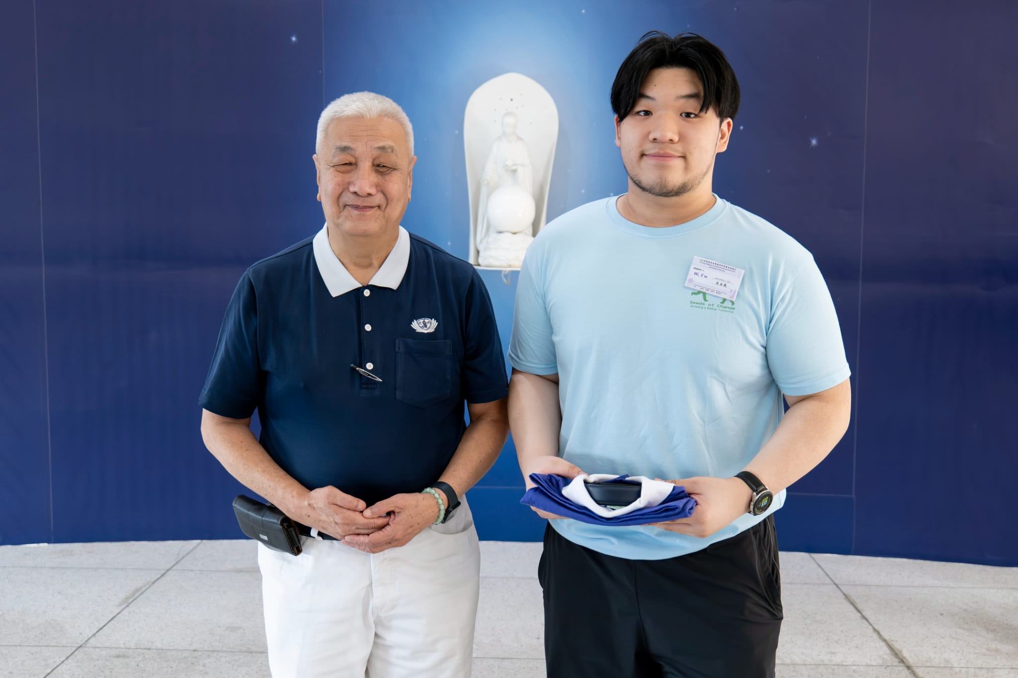 Coby Mykhel Ong (right) receives his Tzu Chi uniform from Tzu Chi Philippines CEO Henry Yuñez.