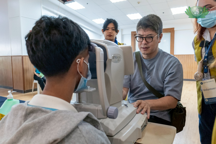 Tokusen Aoki of Paris Miki checks a scholar’s eyes through an automated refractor. “What I really appreciate is everybody is doing social work from the bottom of their heart,” he says.