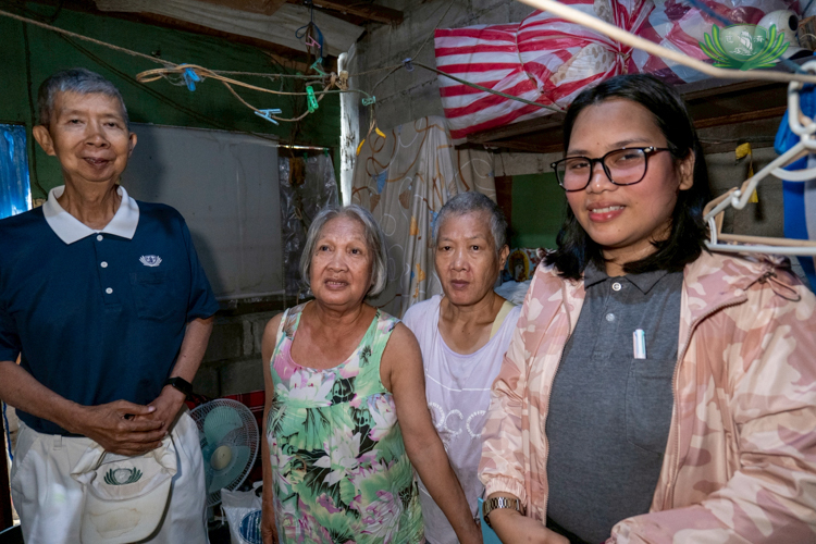 Flanked by Tzu Chi volunteer Rudy Ong (first from left) and registered social worker Lyka Tigas, (first from right), medical assistance beneficiary Reynalda Francisco and her daughter Imelda Reyes (second and third from left) are grateful to receive provisions amid continuous monsoon rains.