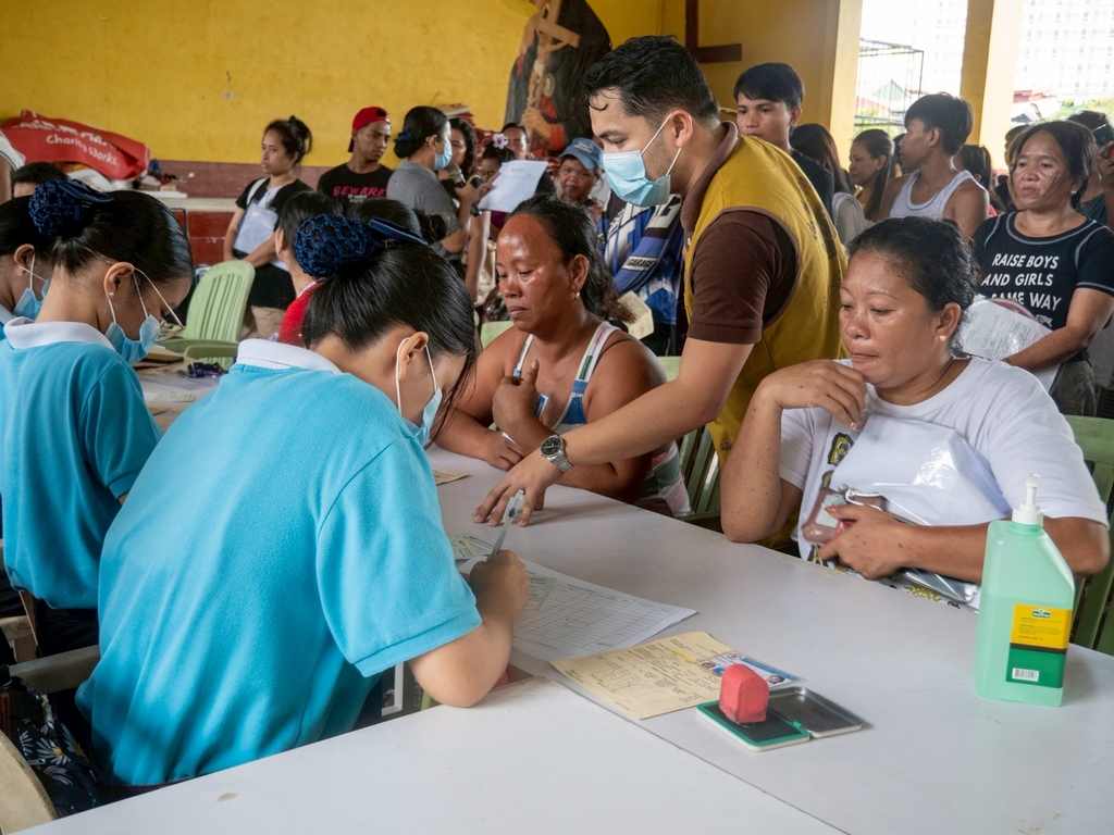 Tzu Chi scholars take part in the stub distribution for the 802 affected families.