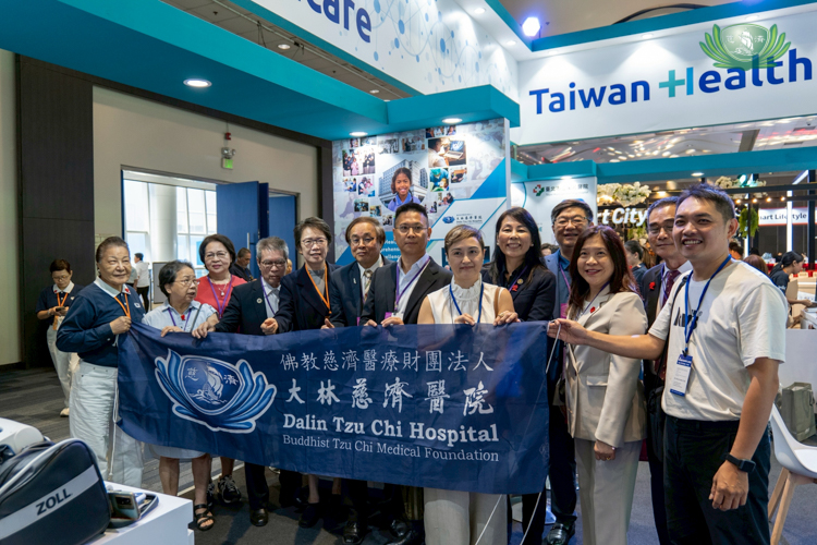 Delegates from Dalin Tzu Chi Hospital proudly raise their banner at their exhibit area. 
