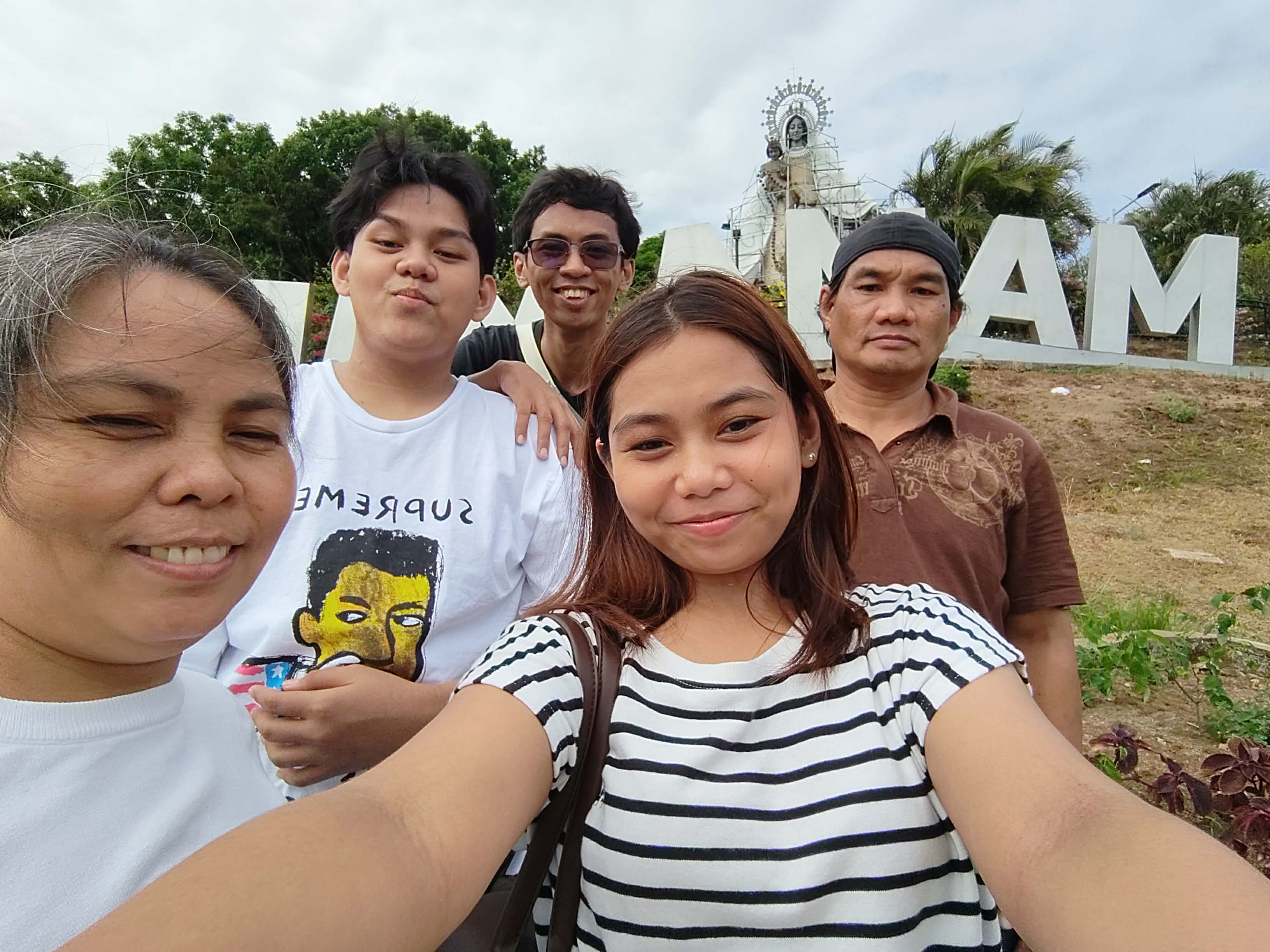 Together in good times and bad: Kenneth’s father (in brown) works as a water proofer, his mother (in white) is an on-call housekeeper, and his two siblings (in striped shirt and white printed shirt) are enrolled in a state college and university.