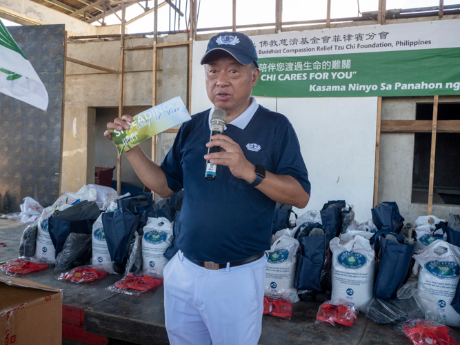 Tzu Chi volunteer Johnny Kwok presents a pamphlet, titled “Spreading the seeds of love,” introducing Tzu Chi’s programs in the Philippines. 