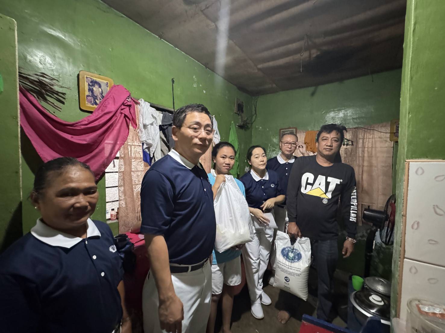 At one point in the home of Trixie Della Marinas (third from left), flood waters were waist-deep. The Grade 12 Tzu Chi scholar and her family were grateful for the provisions and visit from Tzu Chi volunteers.