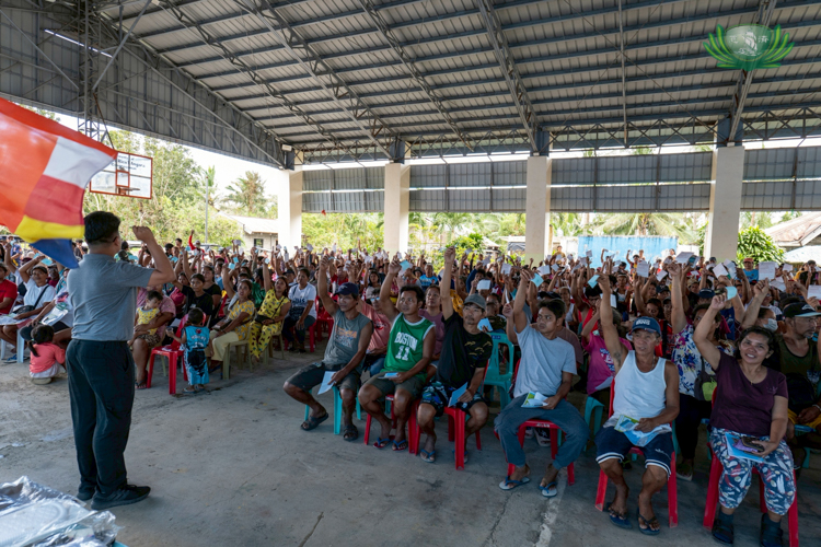 Excited residents wave their stubs in anticipation of claiming the distributed relief goods.
