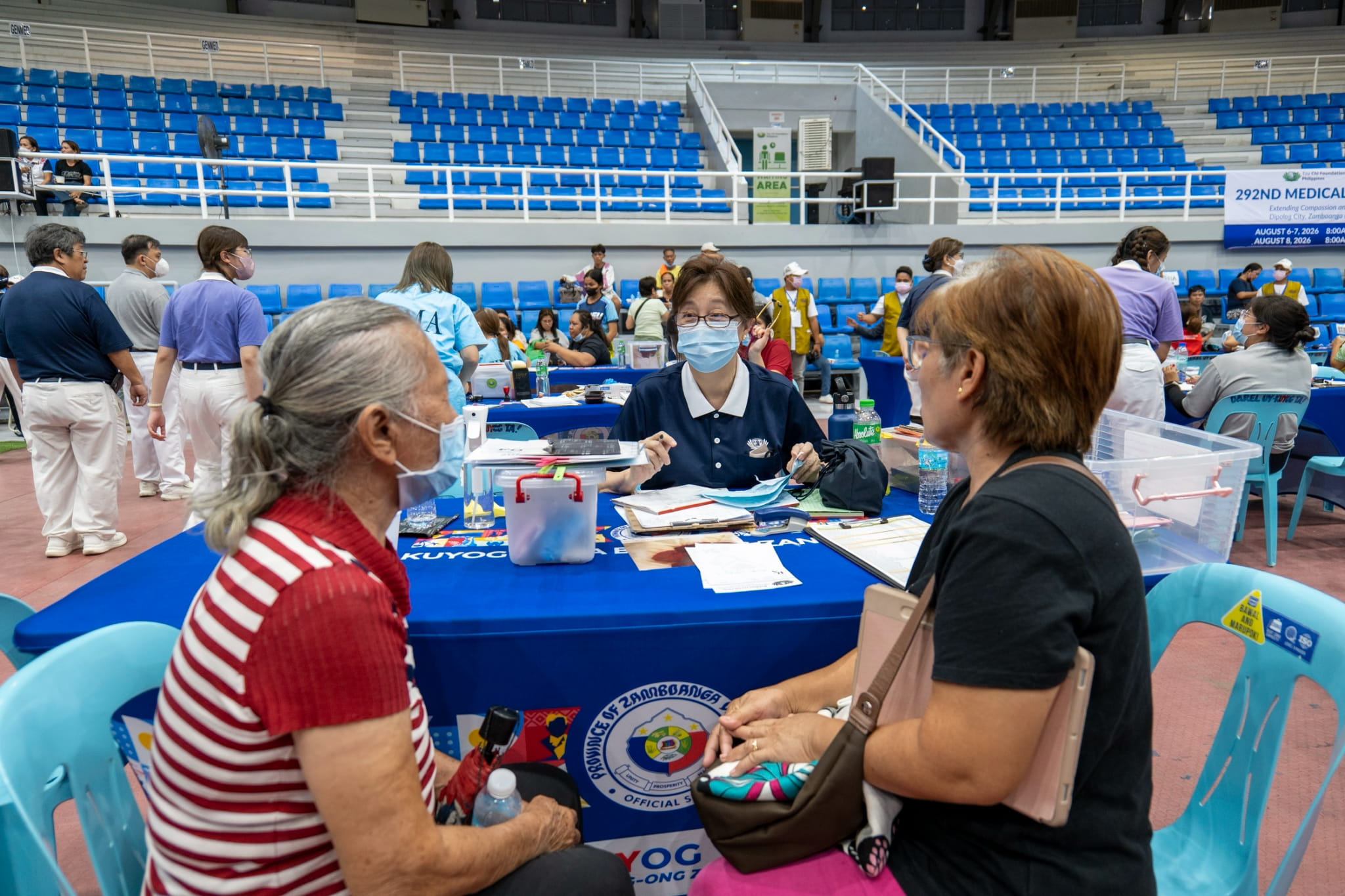 Patient Lonie Returco (in black) assists her senior citizen mother (in red) in inquiring about the available ENT services.